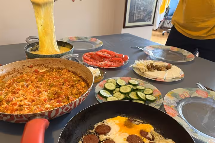 Local host serves stretchy melted cheese beside menemen and fried eggs for an authentic Turkish breakfast