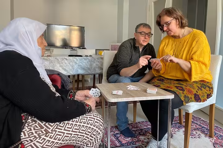Guests learn a Turkish card game with a local grandma at home, part of an afternoon Turkish tea experience