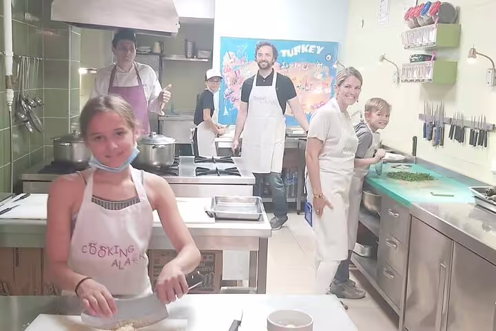Travelers in a Turkish cooking class kitchen, a fun add-on experience during a private guided Istanbul tour