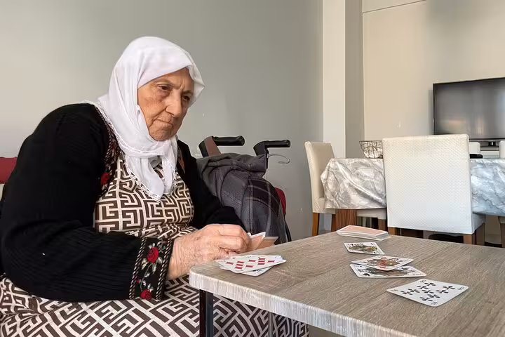 Local Turkish grandma deals cards at a home table, part of an authentic afternoon Turkish tea and card game tour