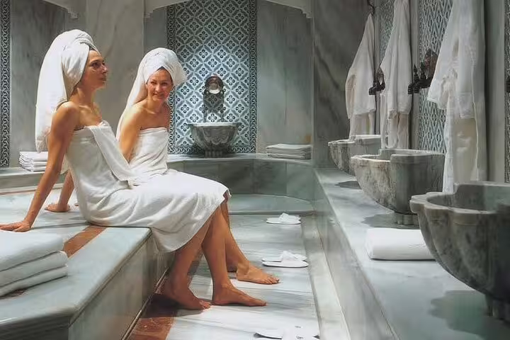 Women relaxing in marble Turkish hamam steam room in Hurghada before VIP full body massage and scrub treatment