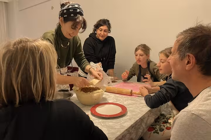 Local Turkish mom teaches a family to fill dough for börek at a private Turkish cuisine cooking class