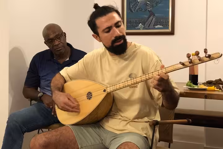 Playing the Turkish saz at a home gathering, experiencing Istanbul local life and cultural immersion in 3 days