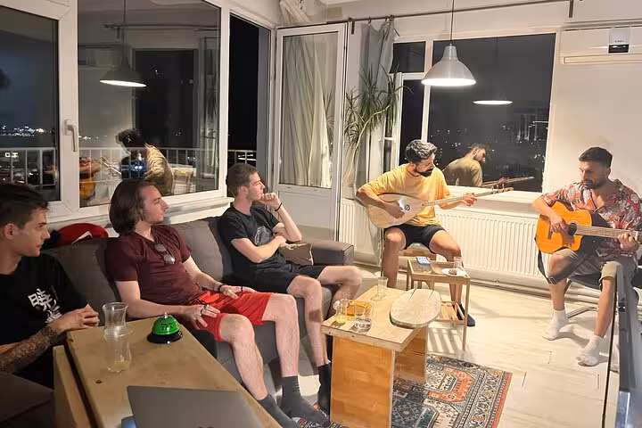 Guests network over Turkish tea in an Istanbul apartment, relaxing with live saz and Bosphorus night views