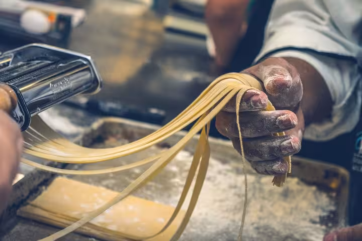 Close-up of hands crafting fresh pasta during a Tuscan cooking class in Rome, showcasing authentic Italian techniques.