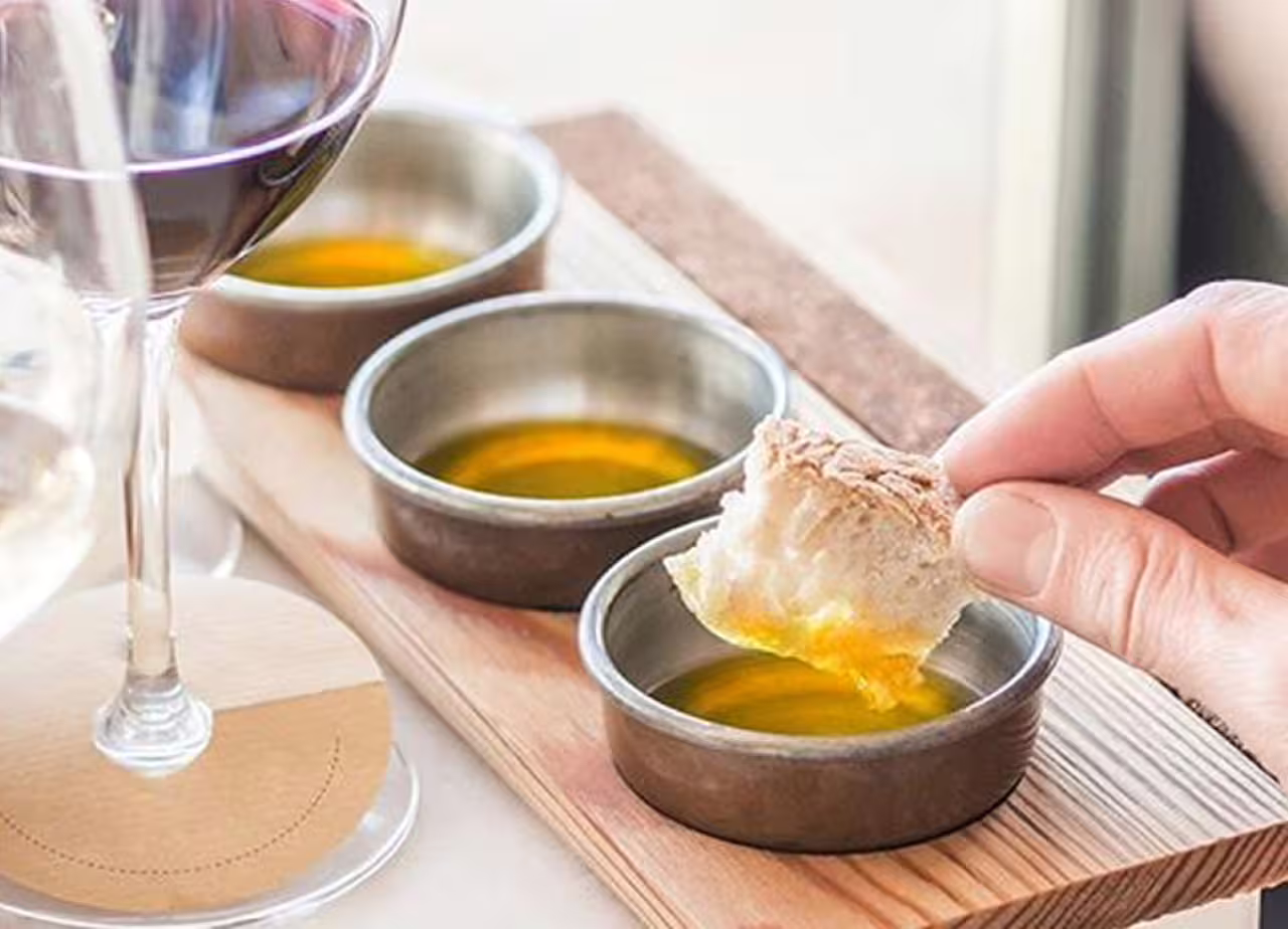 Dipping bread into Tuscan extra virgin olive oil during Fiesole EVO Gold Experience at Frantoio Buonamici