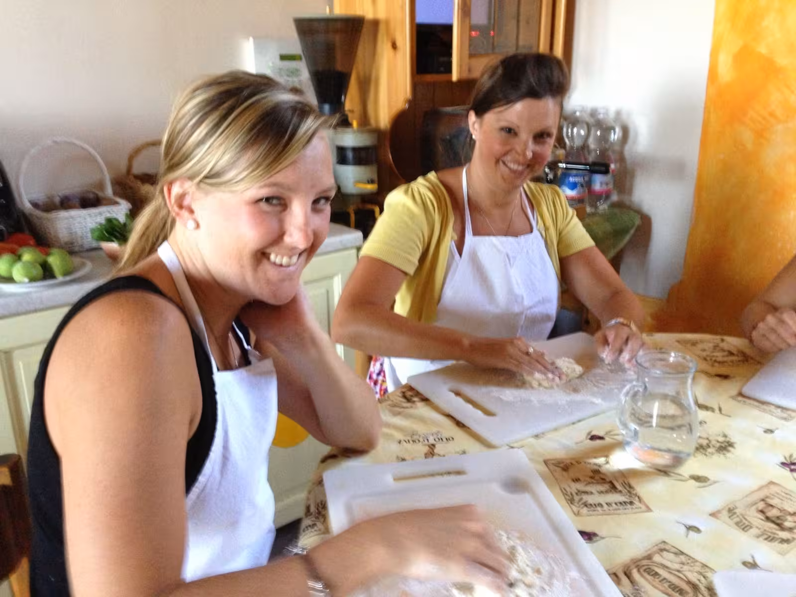 Participants enjoy hands-on pasta-making at a rustic Tuscan farmhouse cooking class.