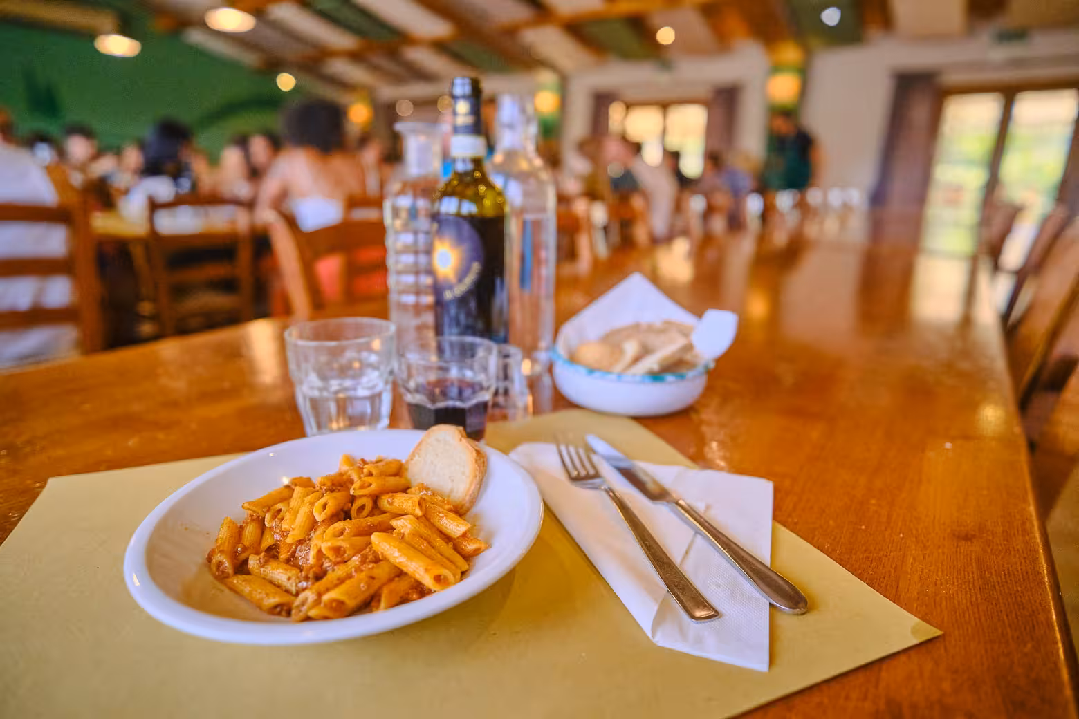 Delicious Italian pasta served with bread and wine in a traditional Tuscan restaurant during a day tour.