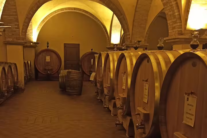 Historic Tuscan wine cellar lined with large wooden barrels for Brunello and Vino Nobile tastings on a private tour