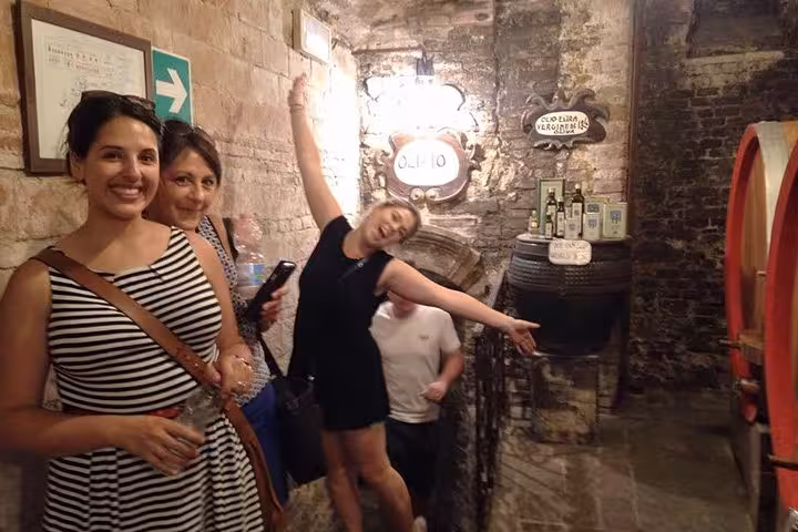 Group of friends exploring a rustic wine cellar in Montepulciano, highlighting Tuscan charm and local wines.