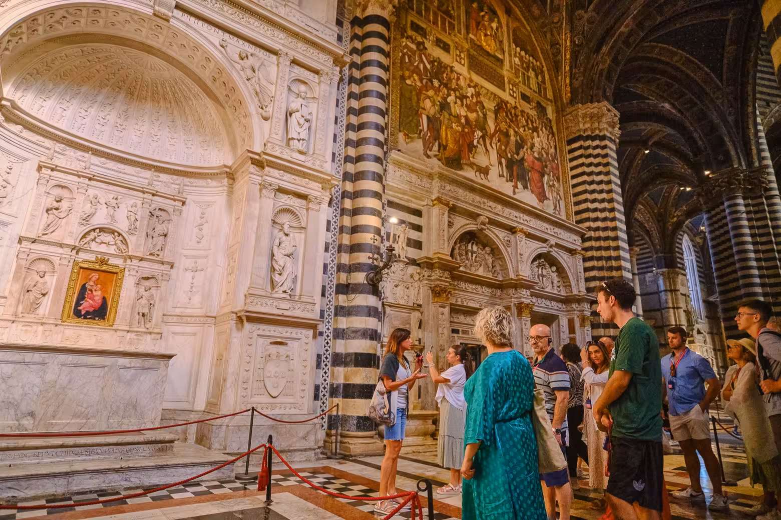 Tour group admiring ornate frescoes and marble in a historic cathedral on the Tuscany Highlights tour.
