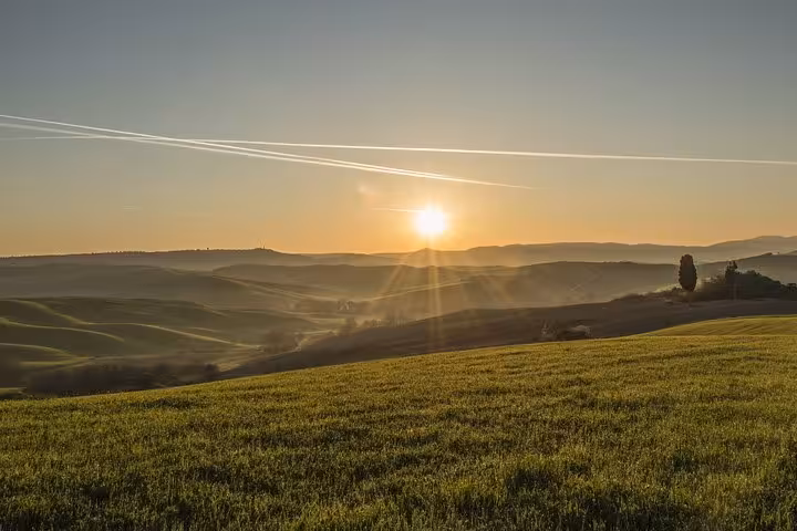 Scenic Tuscany countryside sunrise on a Rome to Florence day trip, showcasing rolling hills and vibrant landscapes.