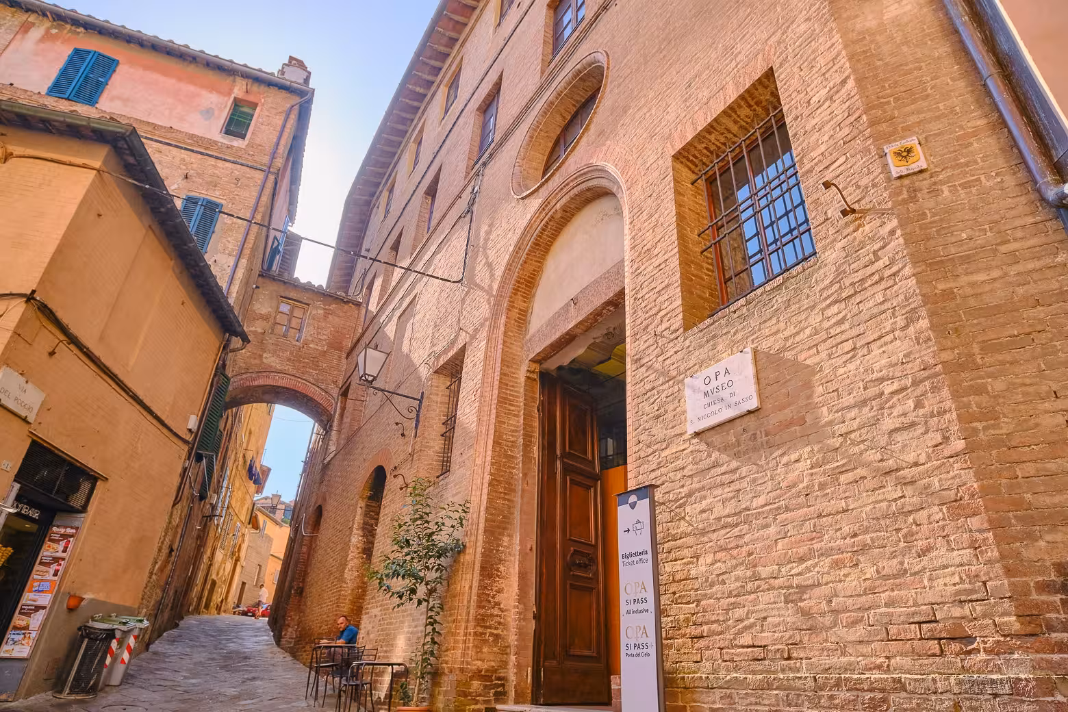 Charming narrow street leading to the OPA Museum in Siena, featured in the Tuscany Highlights Tour from Florence.