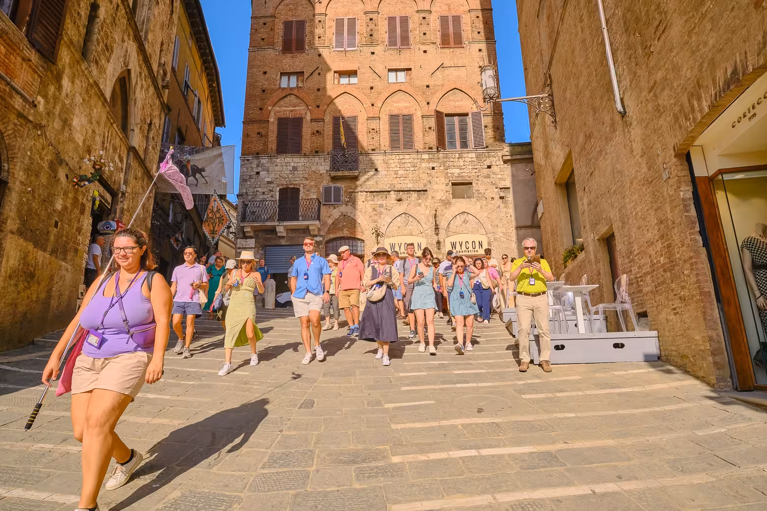 Tourists enjoying a guided walk through the historic streets of Siena during the Tuscany Highlights Tour.