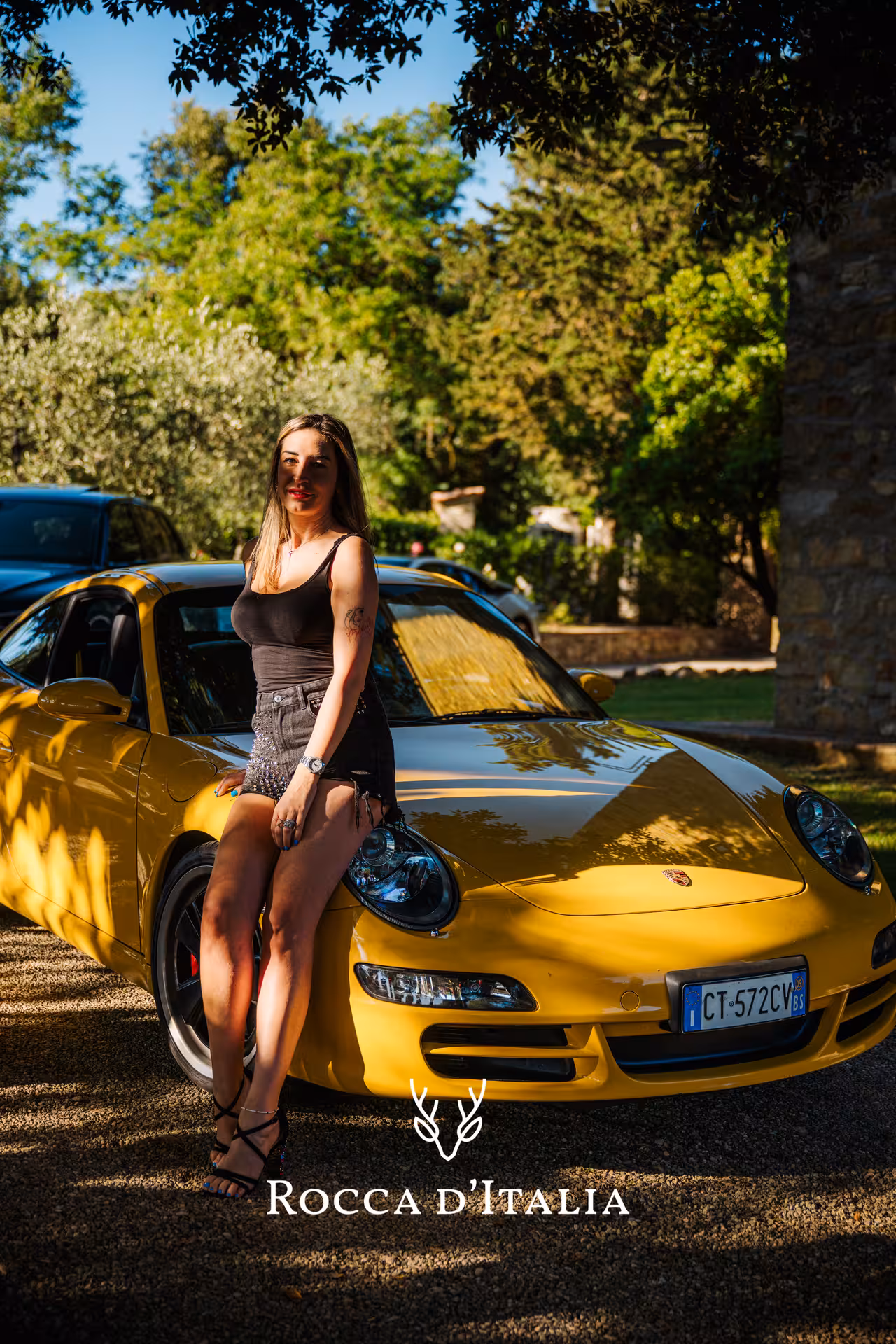 Experience a Tuscany supercar tour featuring a sleek yellow sports car nestled in lush greenery.