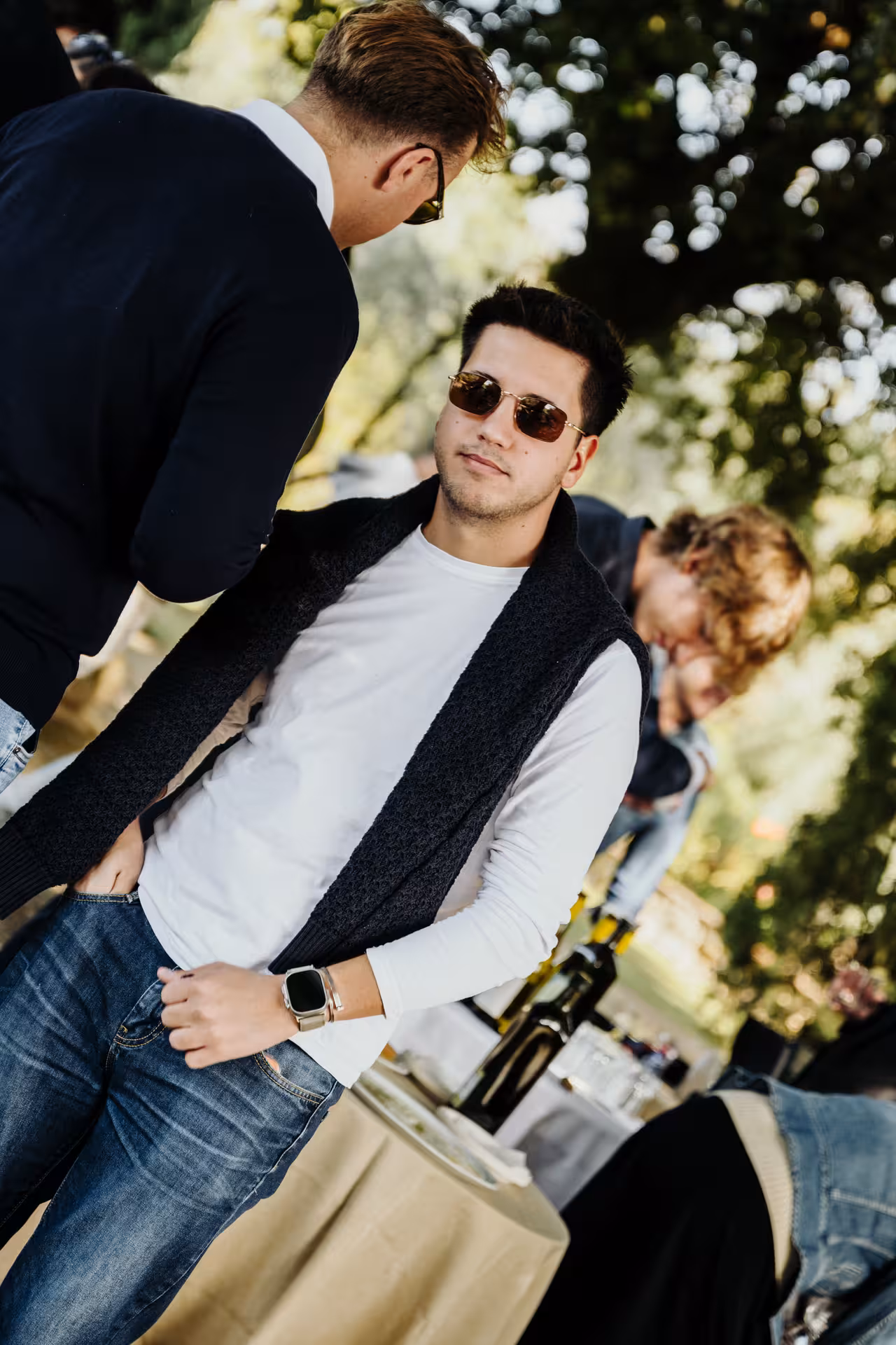 Young man in sunglasses and vest at outdoor wine tasting event in Tuscany