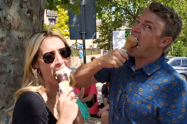 Couple enjoying gelato under sunny skies during Tuscany Wine Tour from Rome.