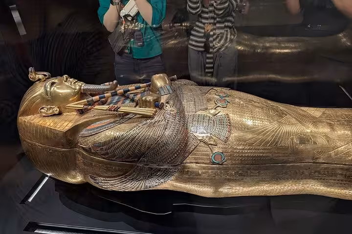 Tutankhamun-style gilded sarcophagus display at Grand Egyptian Museum on half-day tour with tickets and lunch