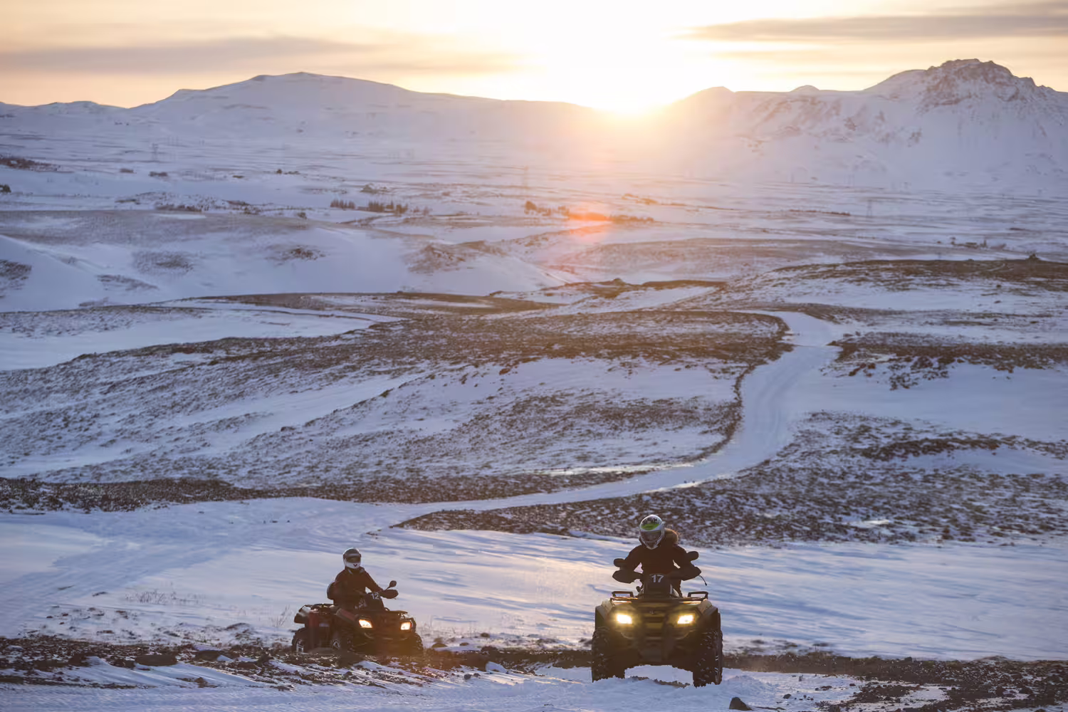 ATV riders explore snow-covered Twin Peaks trails at sunrise, offering thrilling adventure and stunning winter landscapes.