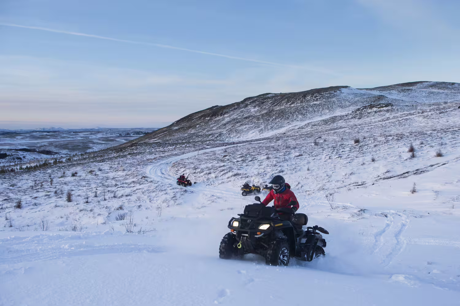 Riders navigate snowy trails on an exhilarating 2-hour Twin Peaks ATV tour, showcasing stunning winter landscapes.