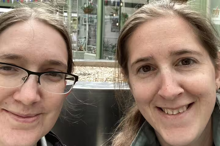 Two women smiling together outdoors near a garden centre in Letchworth Garden City