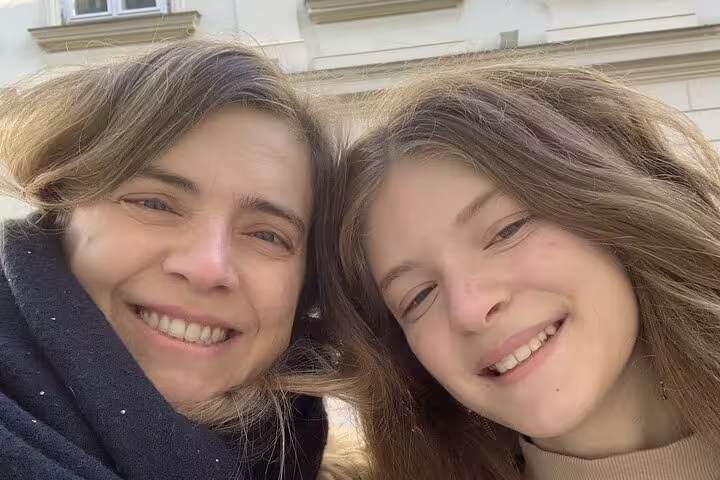 Two smiling women posing together outdoors in Prague on a walking tour
