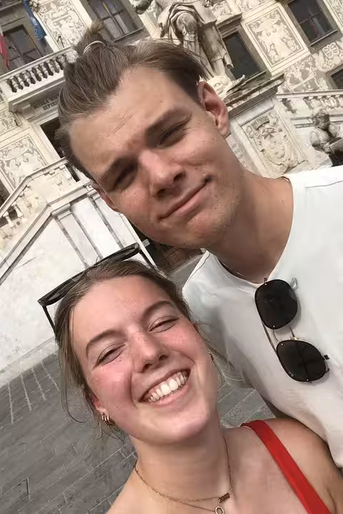 Happy couple smiling during a self-guided mystery puzzle walking tour adventure in Pisa Italy
