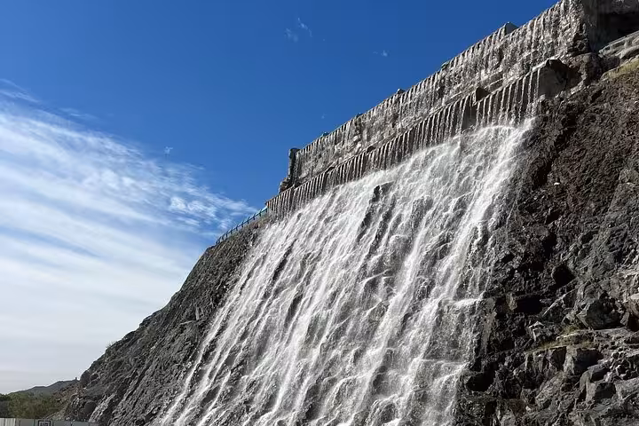 Water cascading over a rocky dam in the UAE mountains, scenic highlight on Emirates history and culture tour