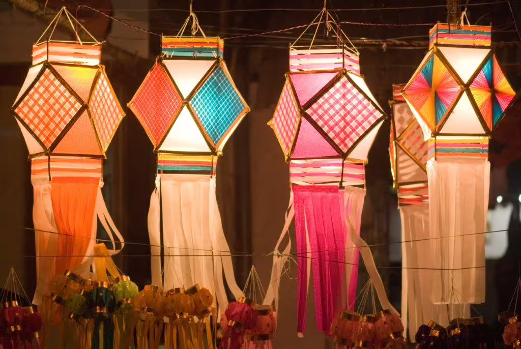 Colorful handcrafted lanterns illuminating a vibrant street market in Udaipur, perfect for Golden Triangle tours.