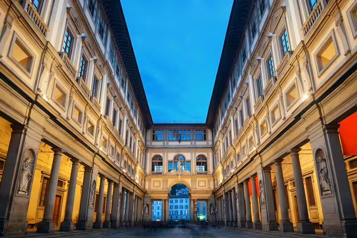 Uffizi Gallery courtyard at dusk, Florence, illuminated Renaissance architecture with arched colonnades