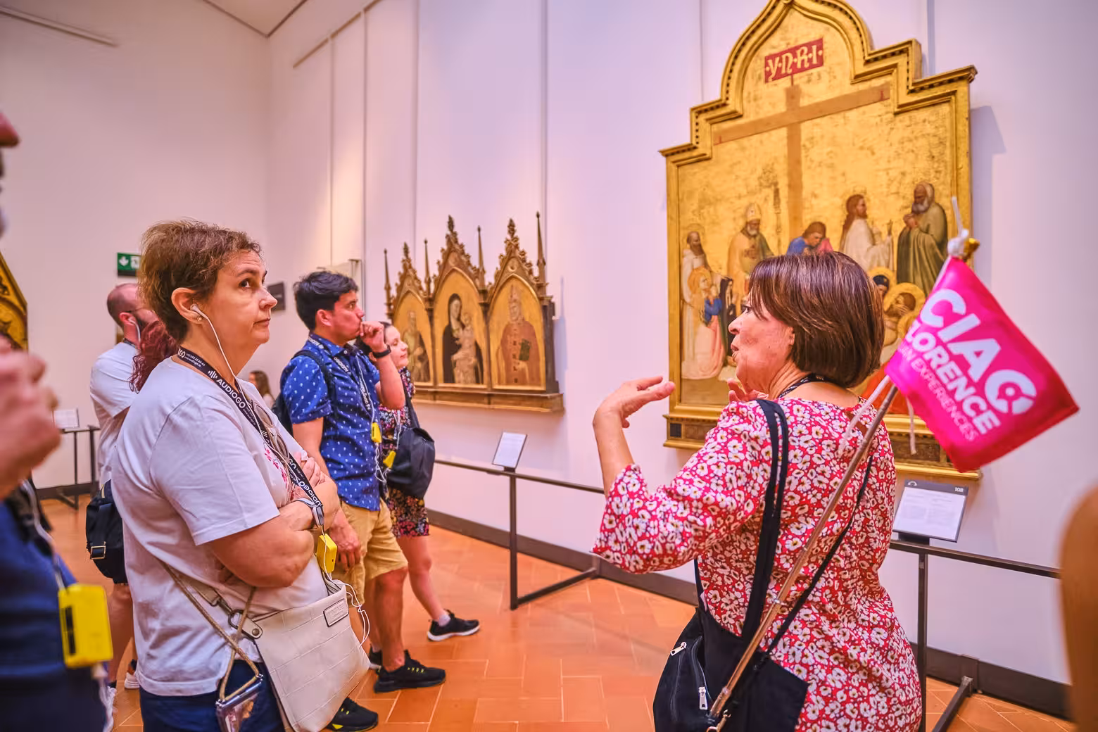 Tour guide explains Uffizi Gallery artwork to engaged visitors on a skip-the-line Florence tour.