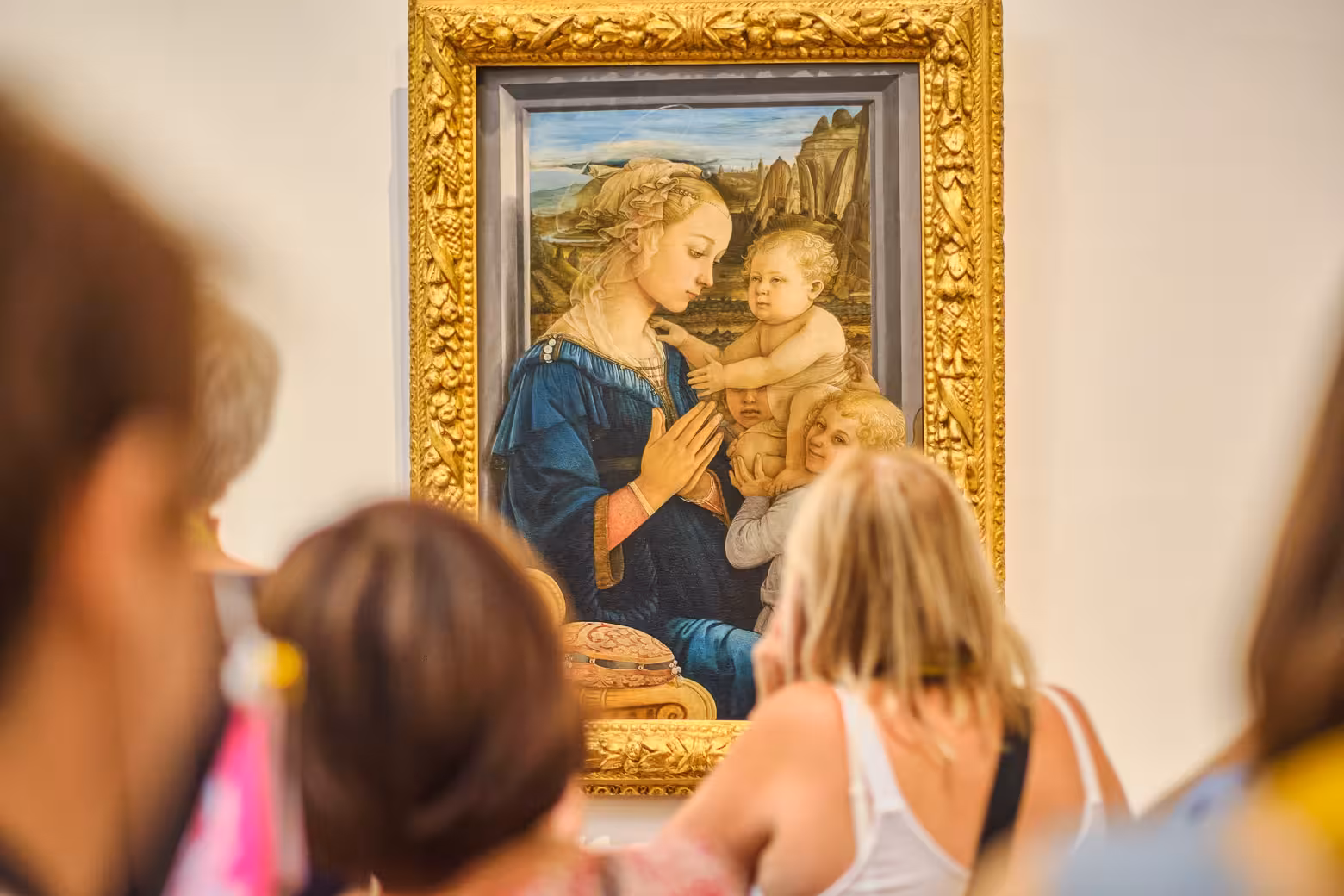 Visitors admire a Renaissance painting at the Uffizi Gallery during a guided tour with skip-the-line access.