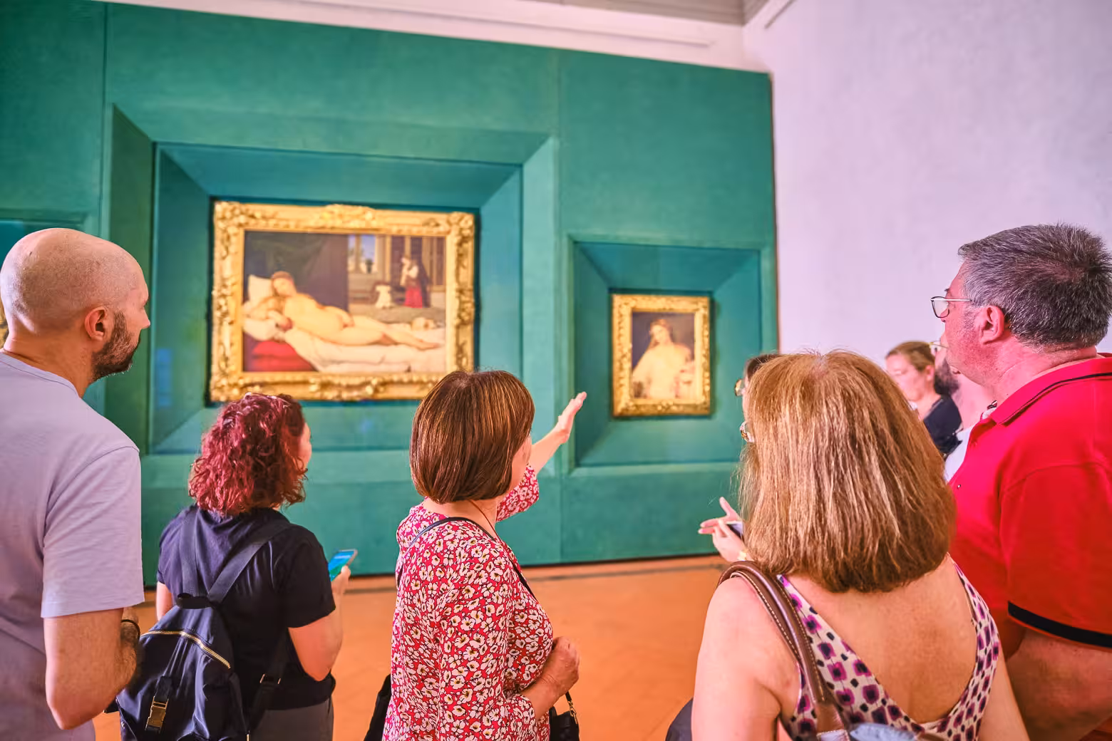 A guide explains famous paintings to a small group on a Uffizi Gallery private tour with skip-the-line tickets.