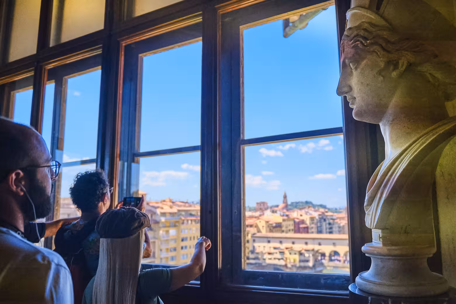 Visitors on Uffizi Gallery private tour enjoy panoramic Florence views through large windows with skip-the-line entry.