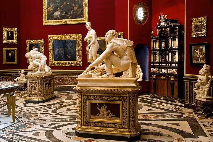 Exquisite sculptures and artwork displayed in a richly decorated room at the Uffizi Gallery in Florence.