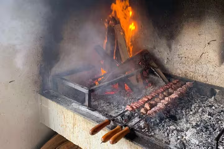 Traditional barbecue with skewers over open flame on The Untraveled West Tour culinary experience.