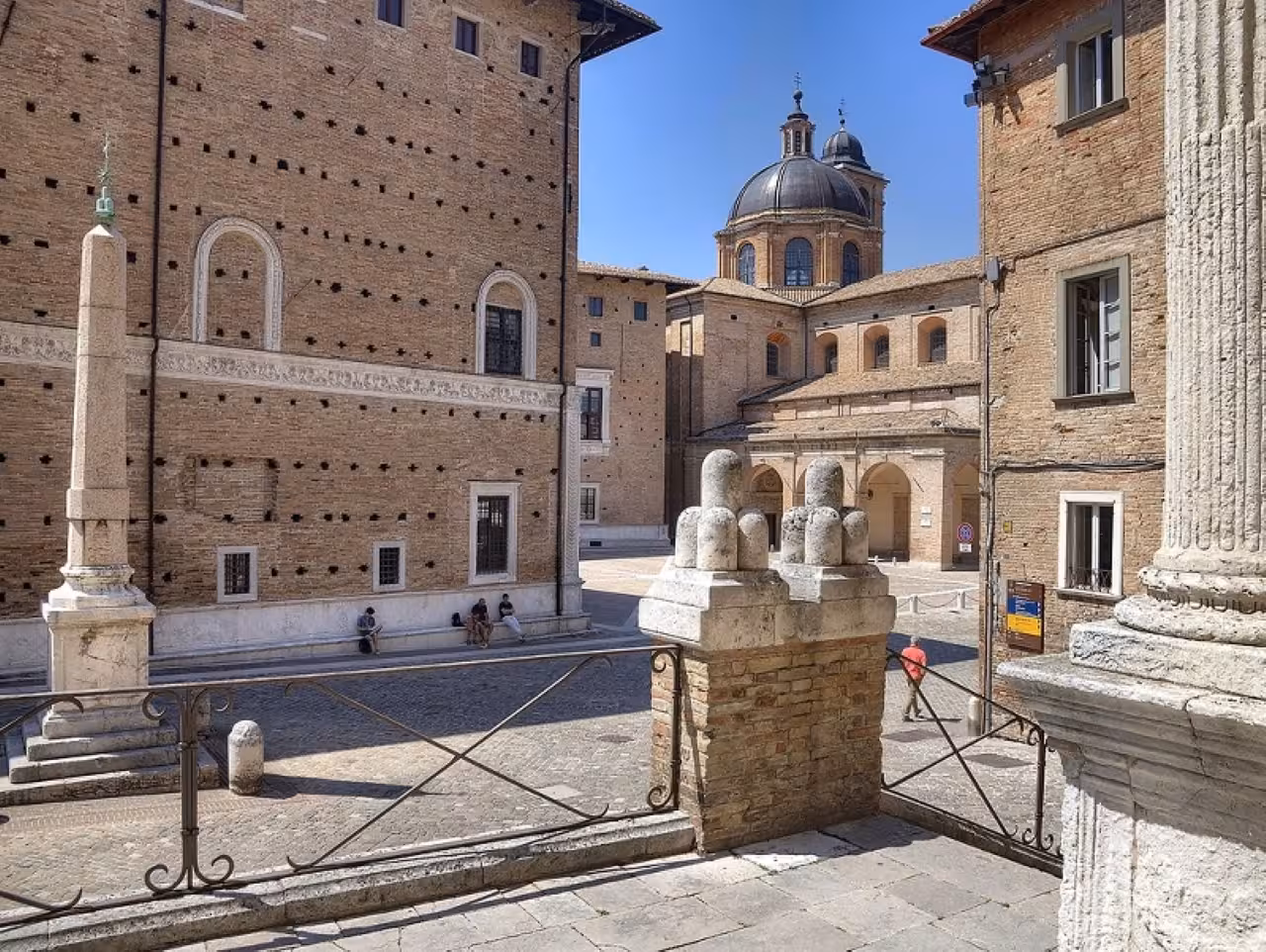 Sunlit courtyard in Urbino near the Duomo, exploring Renaissance architecture on a guided history and flavors tour