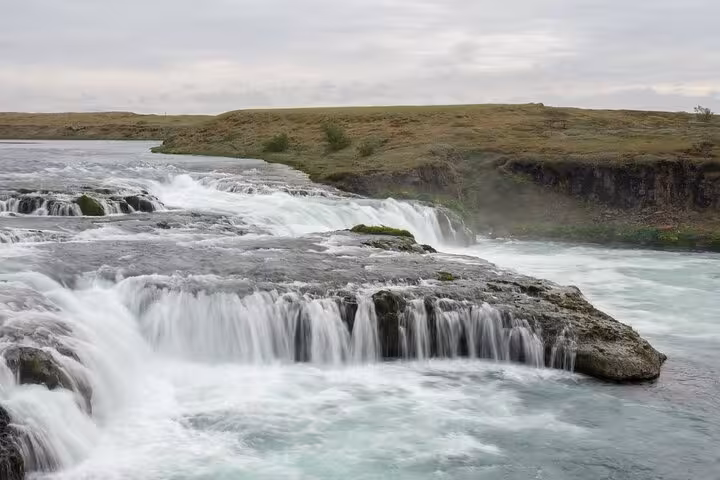 Urridafoss waterfall cascading over rocky ledges on Iceland's South Coast under cloudy skies