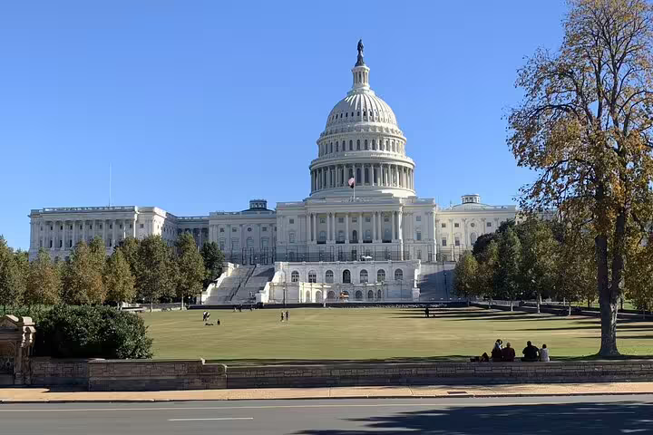 US Capitol Building with green lawn and trees on a clear sunny day in Washington DC