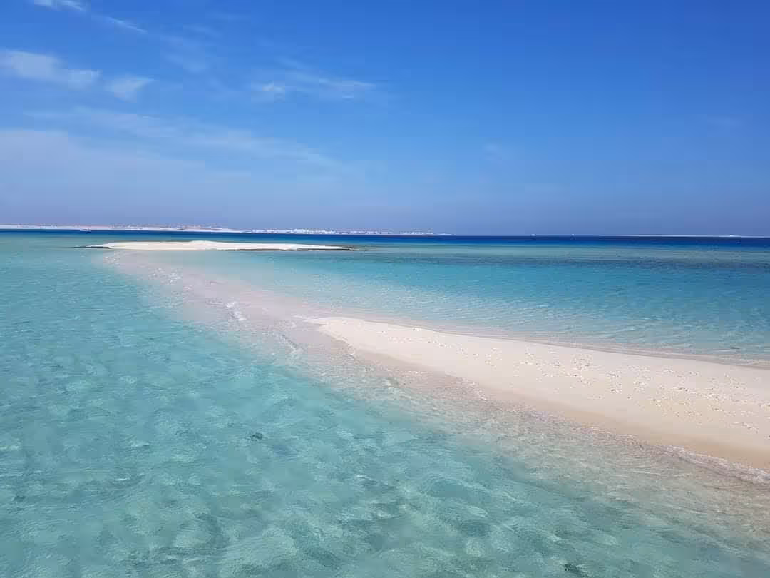 Crystal clear turquoise waters surrounding a white sand sandbar at Utopia Island, Hurghada, Egypt
