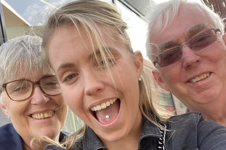 Three smiling people posing for a selfie outdoors in Utrecht city center