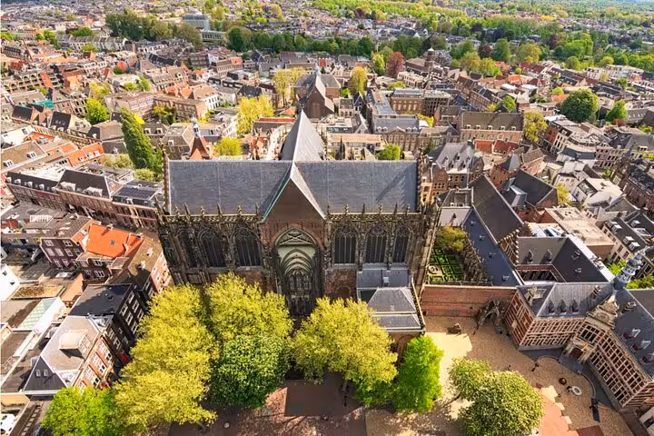 Aerial view of Utrecht's medieval Dom Church surrounded by historic city buildings and green trees