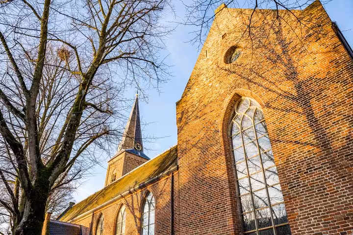 Historic medieval brick church with Gothic windows and pointed steeple in Utrecht, Netherlands