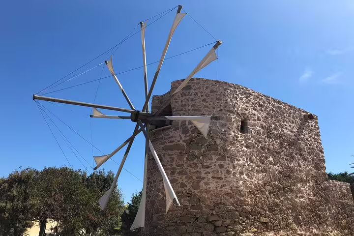 Historic stone windmill basking in the sunlight, a highlight of the Vai Beach and Monastery Toplu tour.