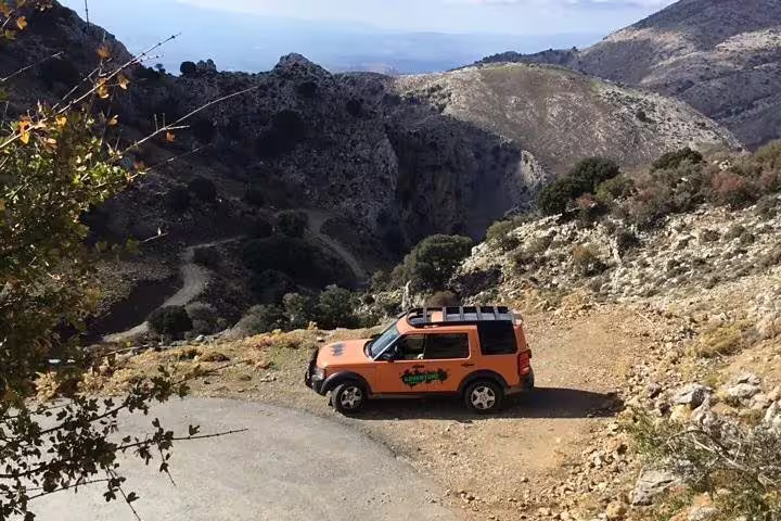Scenic mountain view with an adventure SUV on the Vai Beach and Toplu Monastery VIP Luxury Private Tour in Crete.