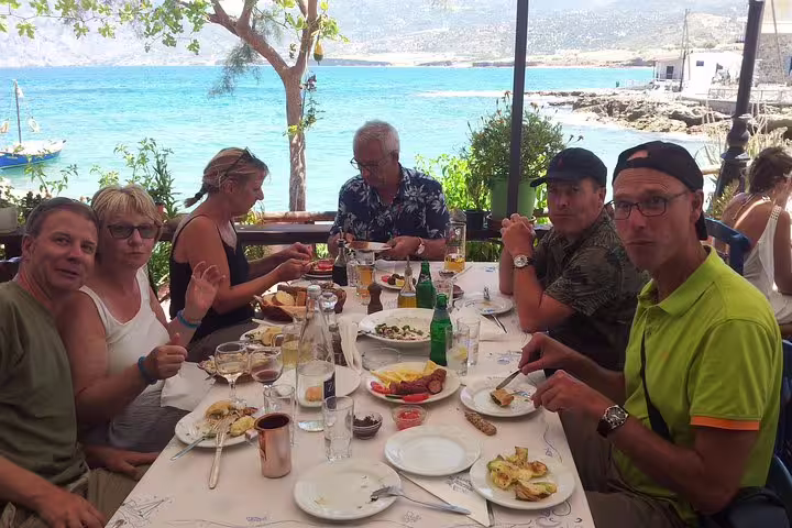 Group enjoying seaside dining during Vai Beach and Toplu Monastery VIP Luxury Private Tour with stunning ocean views.
