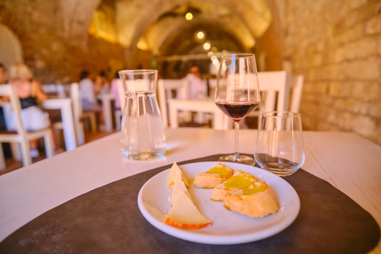Enjoy a wine and cheese tasting experience in a rustic Montalcino cellar during the Val d'Orcia private tour.