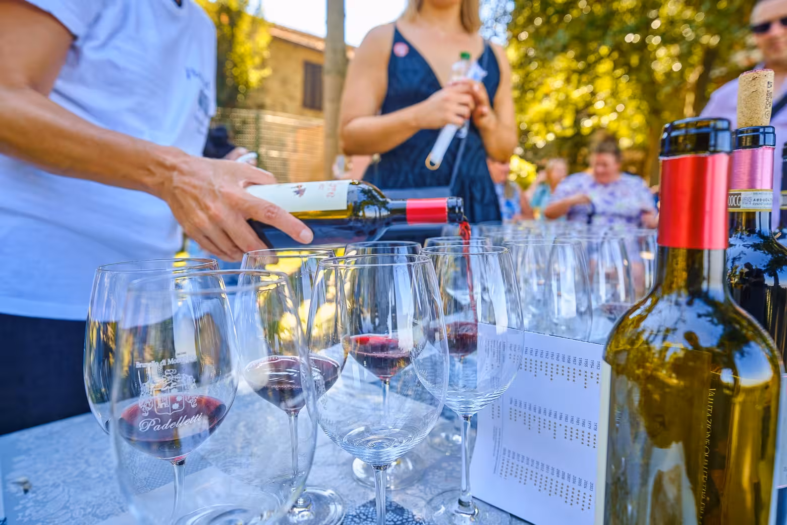 Wine being poured into glasses at a tasting event in Val D'Orcia during a tour of Tuscany's vineyards.