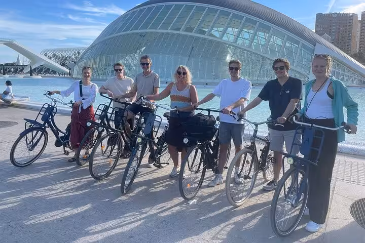 Cyclists on Dutch Valencia bike tour posing at the City of Arts and Sciences by the turquoise water