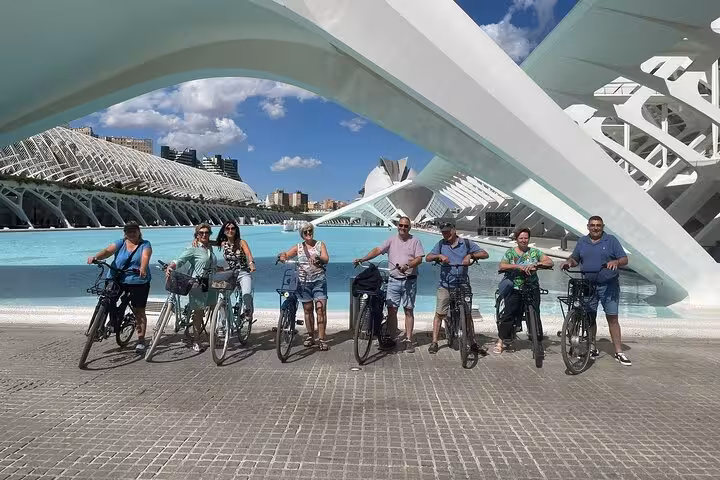 Dutch-guided Valencia bike tour group at City of Arts and Sciences, cycling by turquoise pools